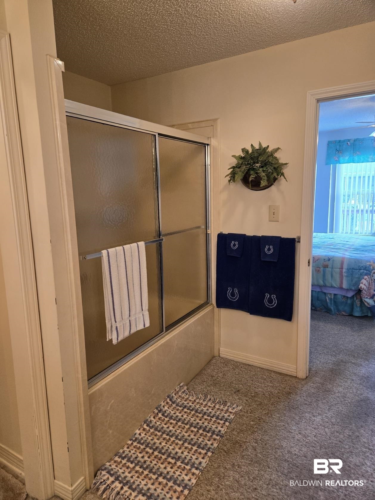 3200 Loop Road, Unit 87 Orange Beach, AL 36561 - Photo 26 of 46 Bathroom with combined bath / shower with glass door and a textured ceiling