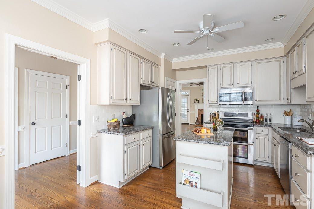 6120 Friars Walk Place Raleigh, NC 27609 - Photo 3 of 21 The open kitchen offers GRANITE counters, work island, TILE backsplash, STAINLESS STEEL APPLIANCES, and HARDWOOD floors.