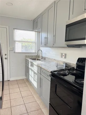 a kitchen with a sink and a stove top oven