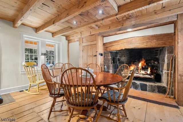a kitchen with stainless steel appliances granite countertop a table chairs in it and wooden floors