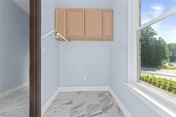 an empty room with a window and a ceiling fan