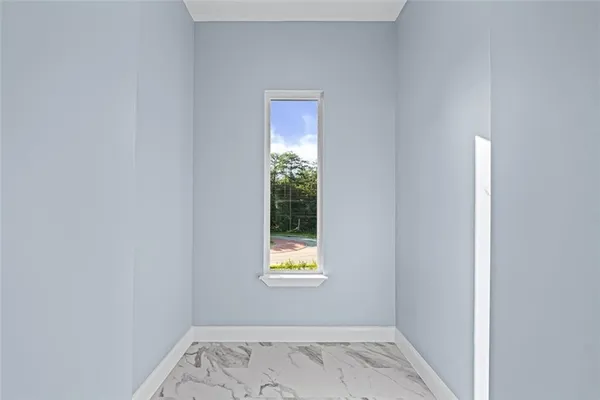 a view of a hallway with wooden floor and a bathroom