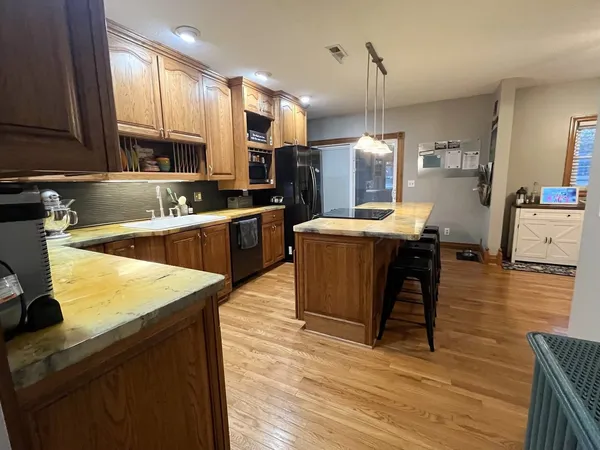 a kitchen with stainless steel appliances granite countertop wooden cabinets a stove top oven a sink and dishwasher
