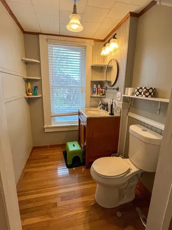 a bathroom with a granite countertop toilet sink and mirror