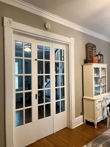 a view of a bedroom with wooden floor and windows