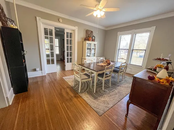 a dining room with wooden floor a glass table and chairs