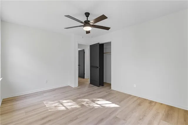a view of a livingroom with a ceiling fan and wooden floor