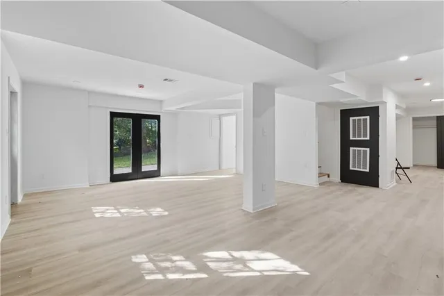 a view of an empty room with wooden floor and stairs
