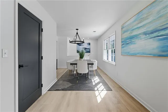 a living room with table chairs and a window