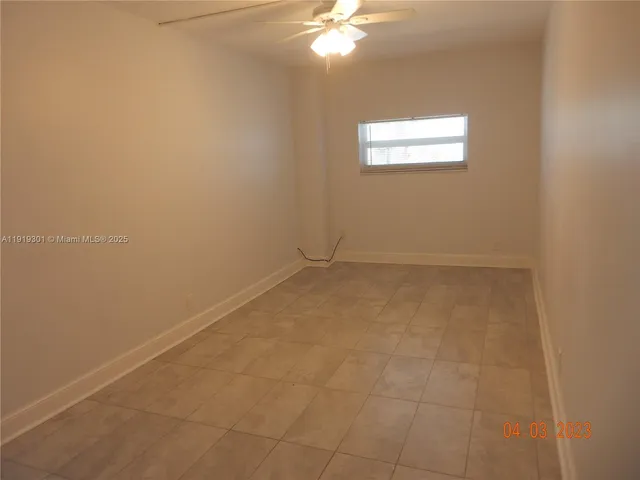 an empty room with a chandelier fan