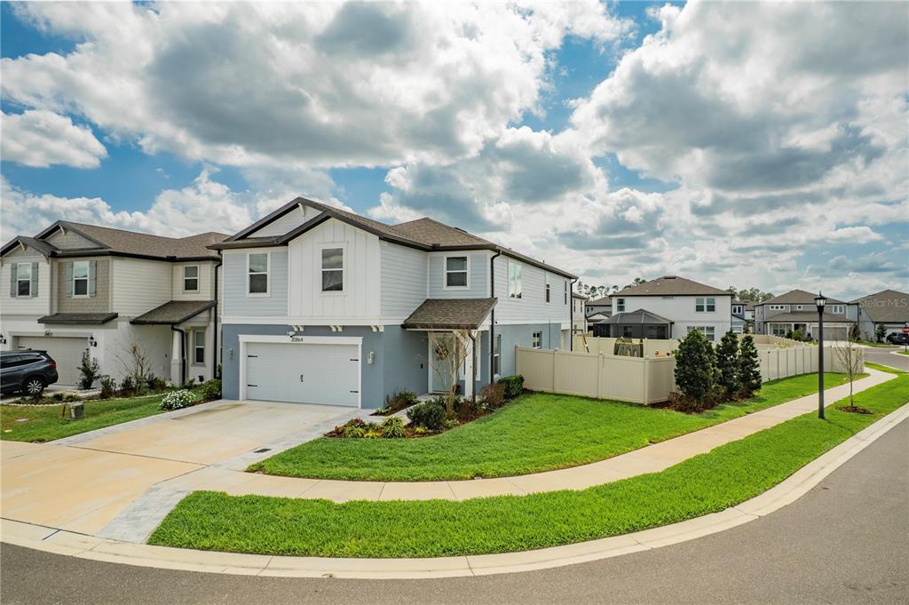 20864 Cherry River Road Land O' Lakes, FL 34638 - Photo 2 of 48 a view of a white house in front of a big yard plants and large trees
