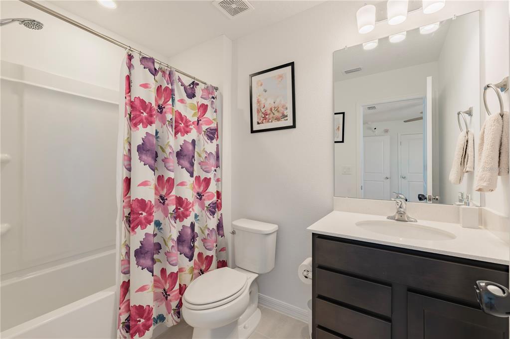 20864 Cherry River Road Land O' Lakes, FL 34638 - Photo 31 of 48 a bathroom with a sink a toilet and shower curtain