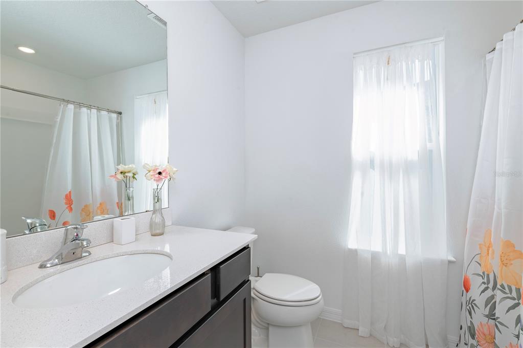 20864 Cherry River Road Land O' Lakes, FL 34638 - Photo 33 of 48 a bathroom with a granite countertop sink toilet and mirror