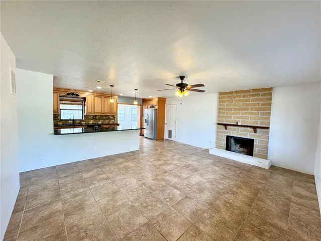 a kitchen with stainless steel appliances granite countertop a refrigerator a sink a stove a microwave a counter space and cabinets