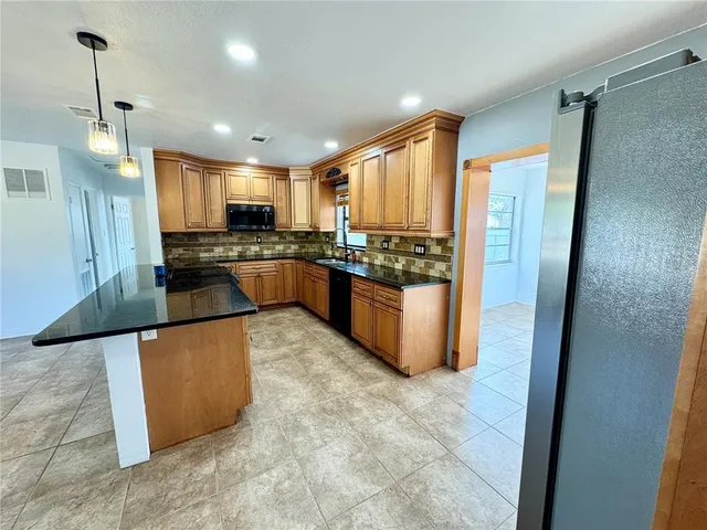 a kitchen with a refrigerator and a stove top oven