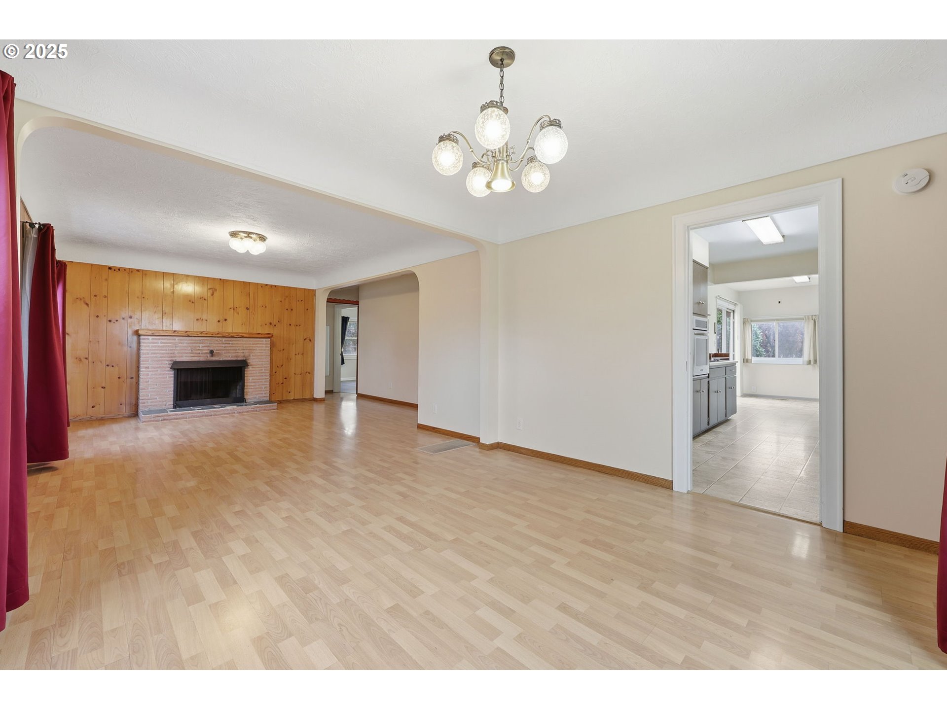 11040 Southeast McCreary Lane Boring, OR 97009 - Photo 8 of 38 a view of an empty room with wooden floor and a kitchen
