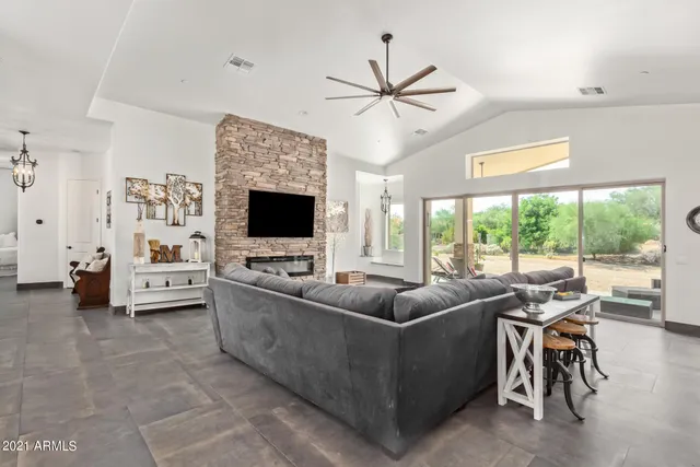 a living room with furniture a flat screen tv and a window