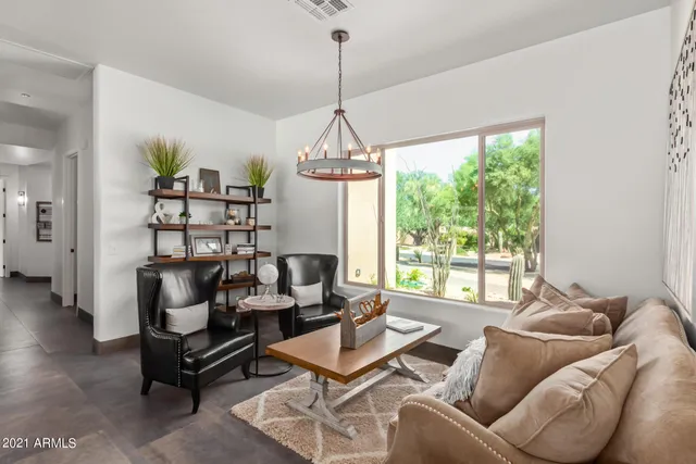 a living room with furniture and a large window with kitchen view