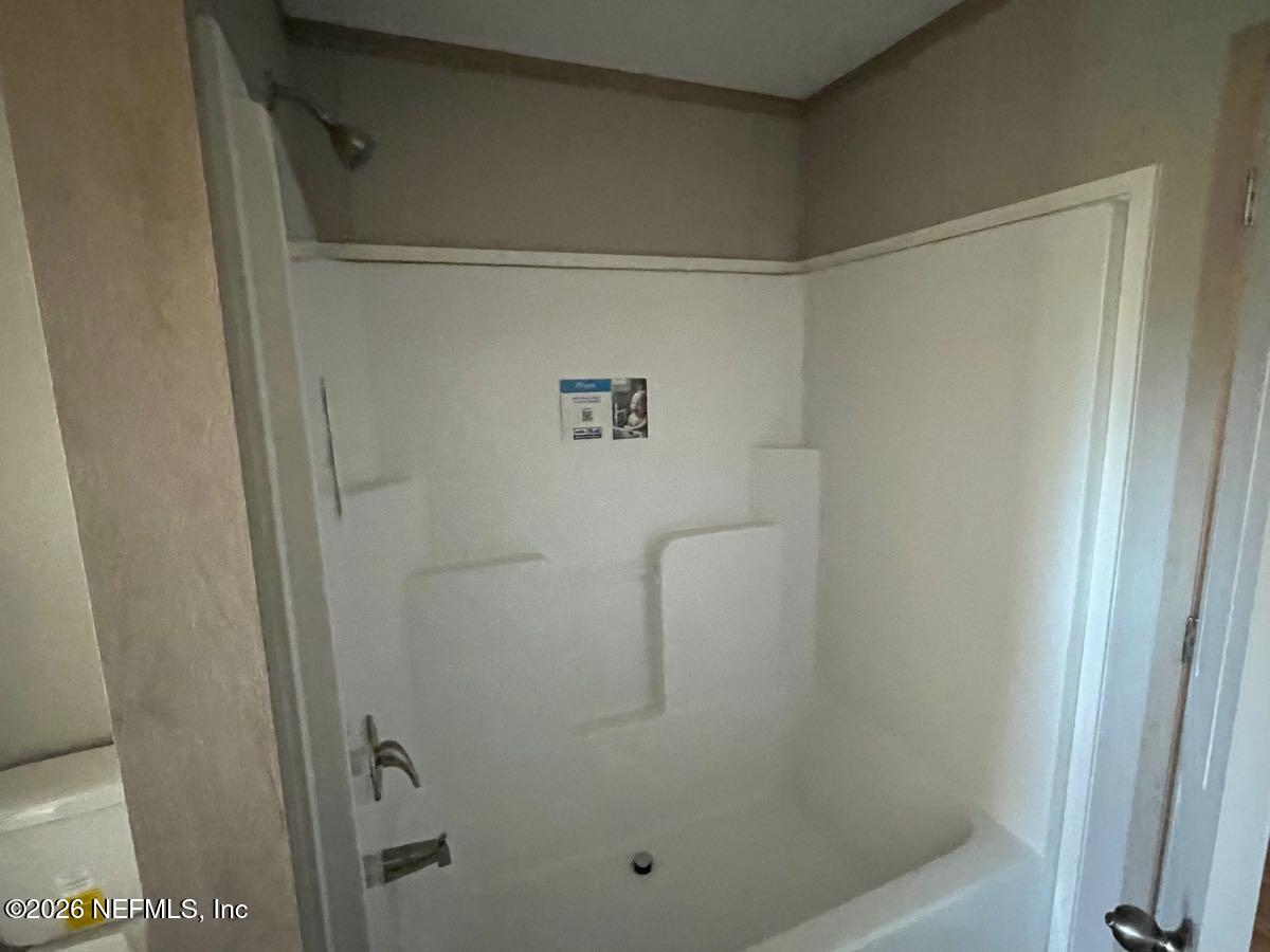 28711 Tracy Road Hilliard, FL 32046 - Photo 15 of 33 a bathroom with a glass shower door