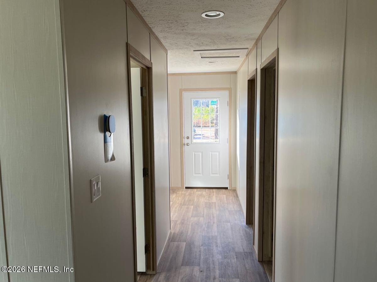 28711 Tracy Road Hilliard, FL 32046 - Photo 16 of 33 a view of a hallway with wooden floor