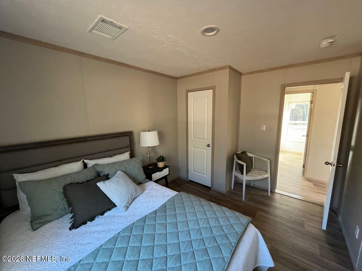 28711 Tracy Road Hilliard, FL 32046 - Photo 18 of 33 a bedroom with a bed and wooden floor