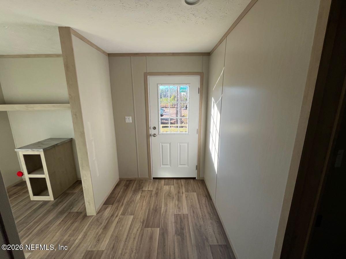 28711 Tracy Road Hilliard, FL 32046 - Photo 23 of 33 a view of a hallway with wooden floor and closet