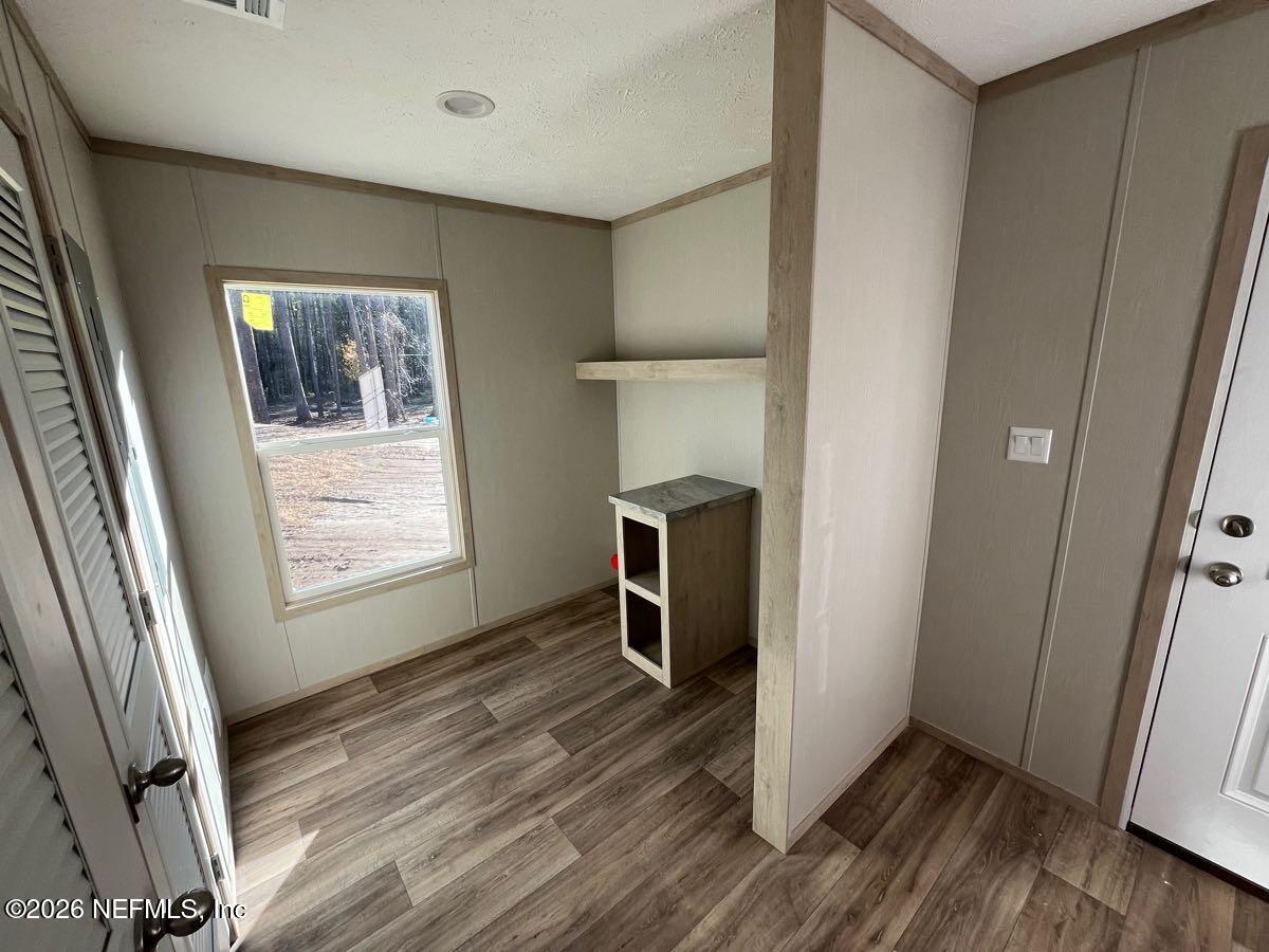 28711 Tracy Road Hilliard, FL 32046 - Photo 24 of 33 a view of empty room with wooden floor and fan