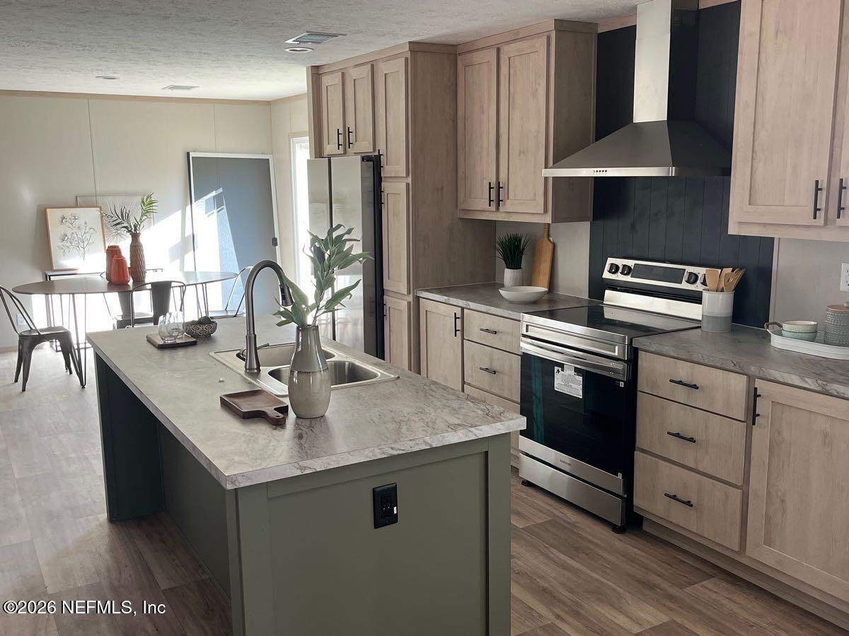 28711 Tracy Road Hilliard, FL 32046 - Photo 5 of 33 a kitchen with stainless steel appliances granite countertop a sink stove and refrigerator