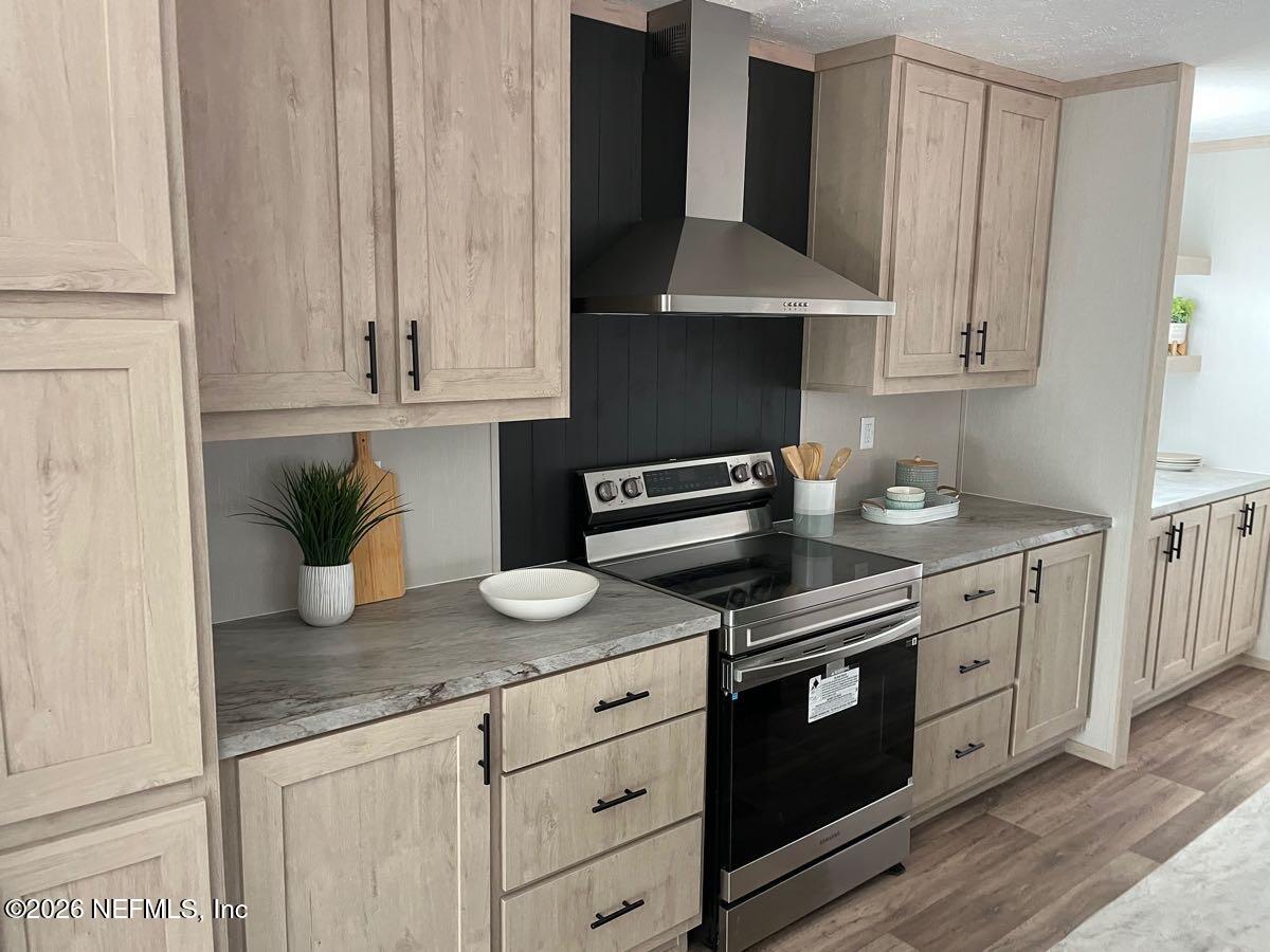 28711 Tracy Road Hilliard, FL 32046 - Photo 6 of 33 a kitchen with stainless steel appliances granite countertop a sink a stove and a microwave