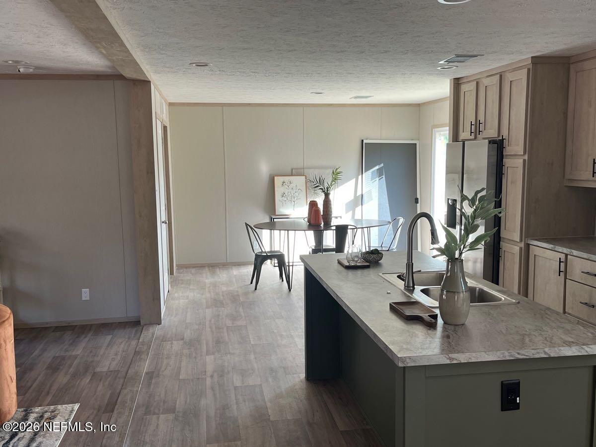 28711 Tracy Road Hilliard, FL 32046 - Photo 7 of 33 a view of kitchen island a sink wooden floor and living room view