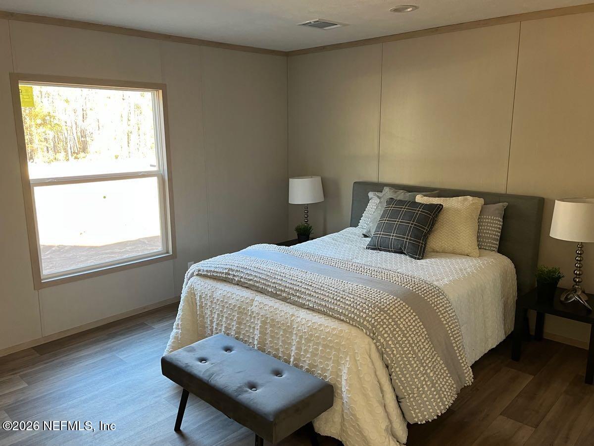 28711 Tracy Road Hilliard, FL 32046 - Photo 9 of 33 a bedroom with a bed and wooden floor