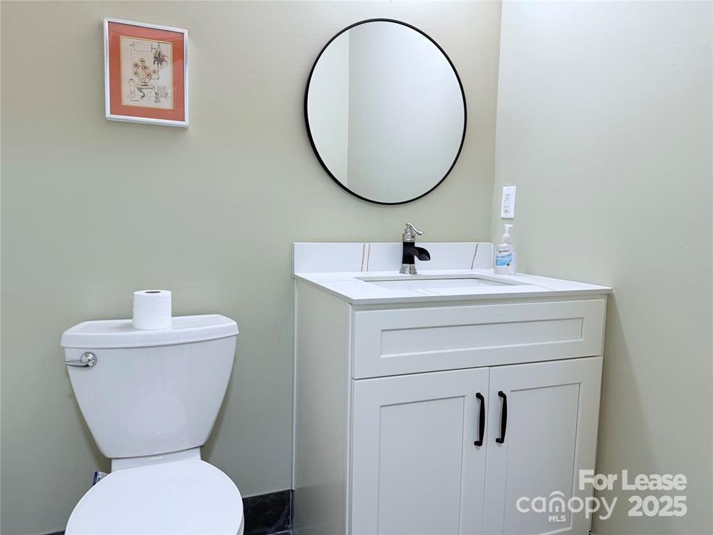5 Elmore Street Asheville, NC 28804 - Photo 27 of 37 a bathroom with a toilet sink and mirror