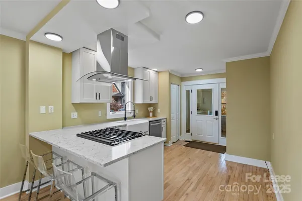 a kitchen with a stove a refrigerator and wooden floor