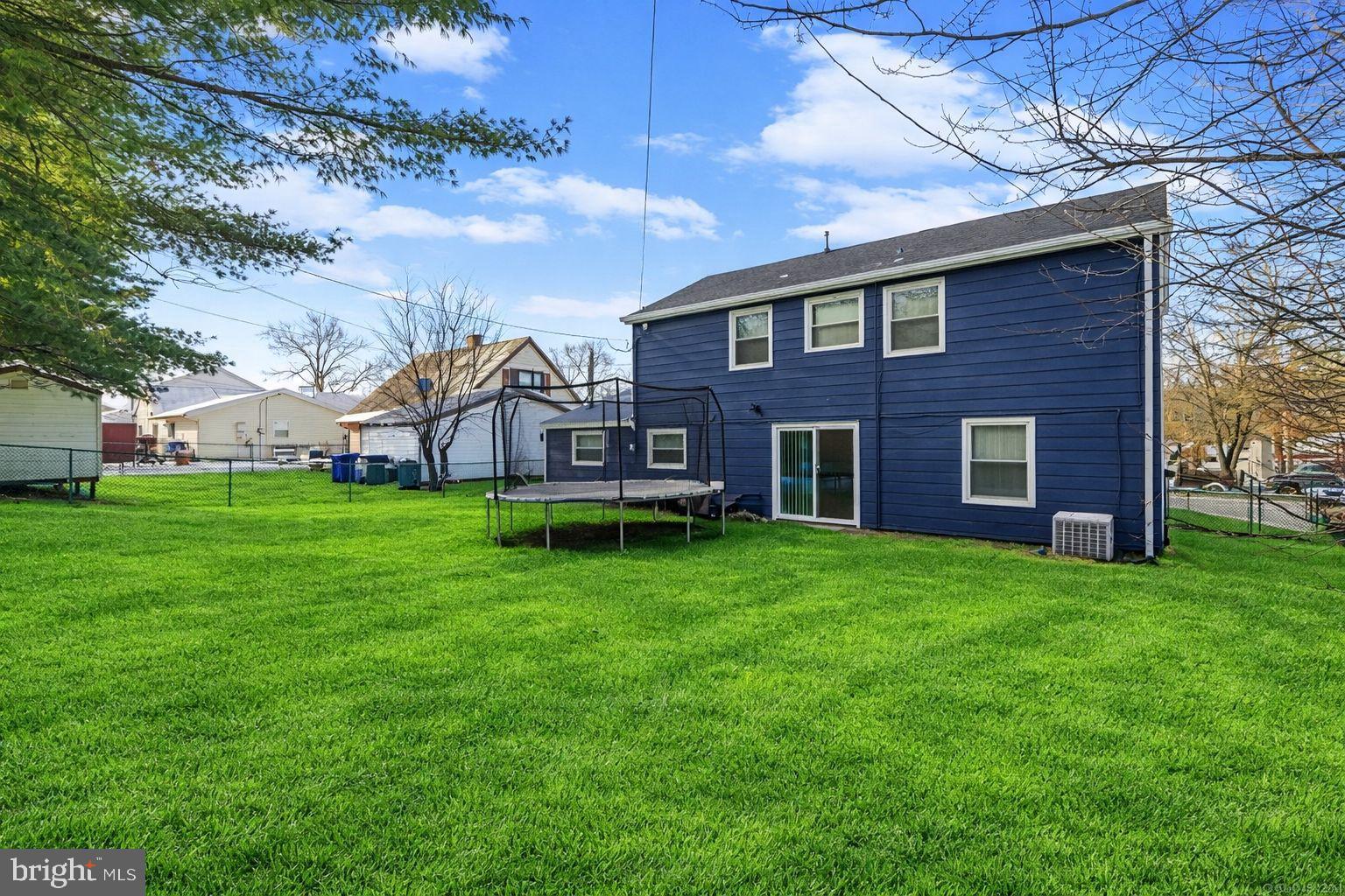 142 Pheasant Lane Willingboro, NJ 08046 - Photo 23 of 24 a view of a yard in front of a brick house with plants and large trees