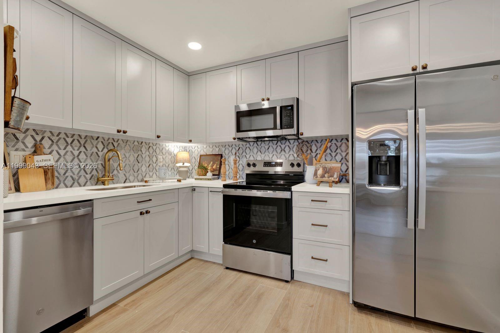 10441 Mahogany Key Circle, Unit 202 Miami, FL 33196 - Photo 11 of 42 a kitchen with stainless steel appliances white cabinets and a refrigerator
