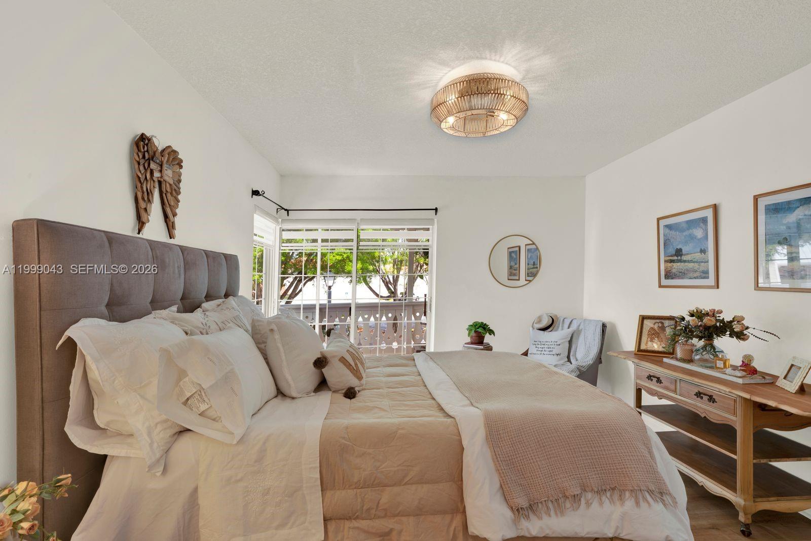 10441 Mahogany Key Circle, Unit 202 Miami, FL 33196 - Photo 13 of 42 a bedroom with a bed and a chandelier