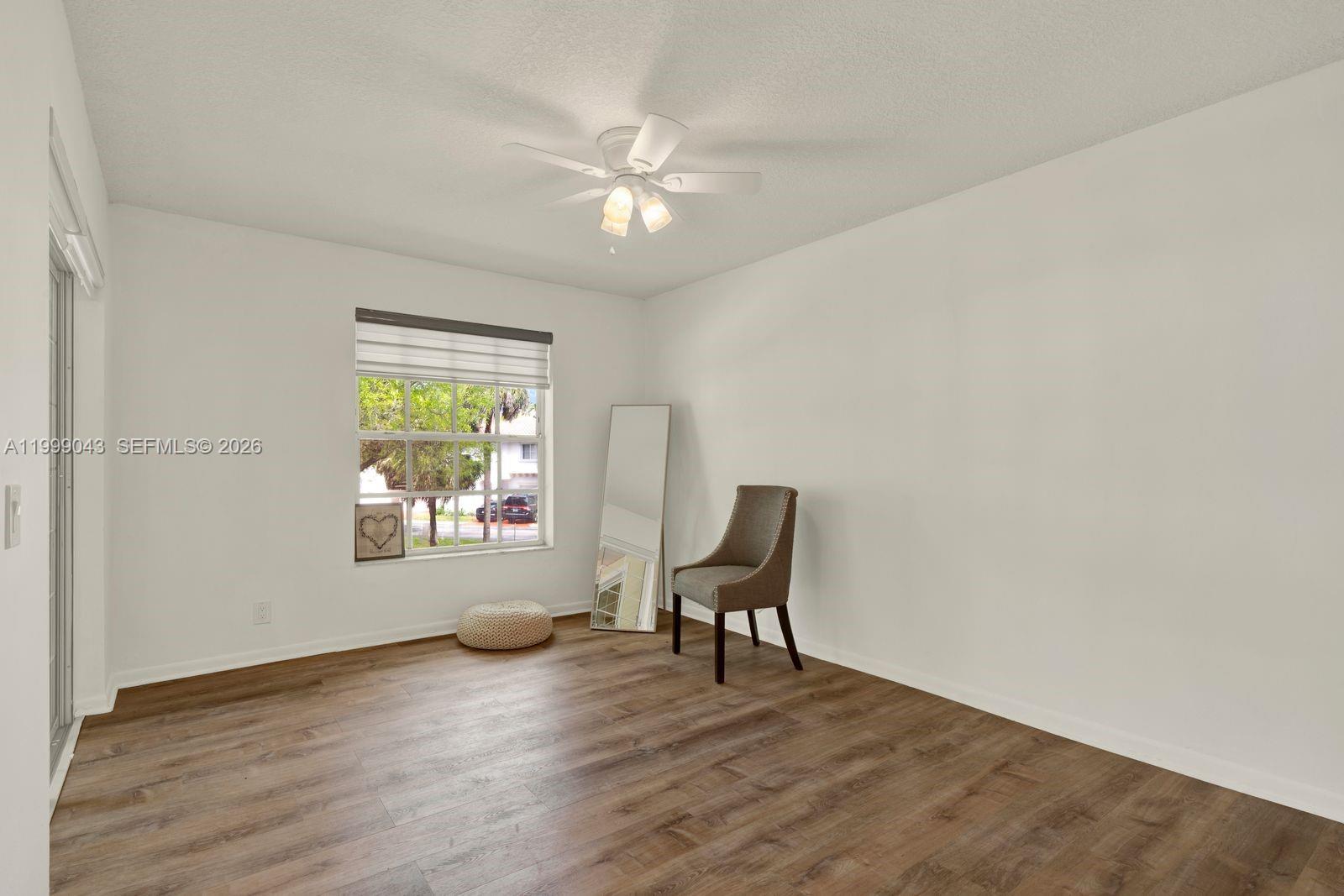 10441 Mahogany Key Circle, Unit 202 Miami, FL 33196 - Photo 21 of 42 a view of an empty room with a window and wooden floor