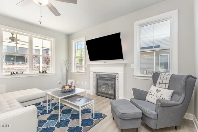 a living room with furniture a flat screen tv and a fireplace