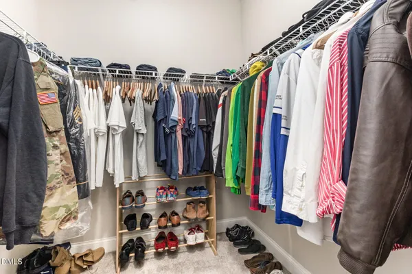 a view of walk in closet with clothes and shoes