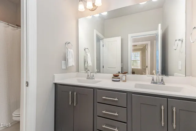 a bathroom with a granite countertop sink double and mirror