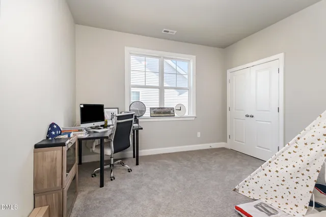a view of a workspace with furniture and a window