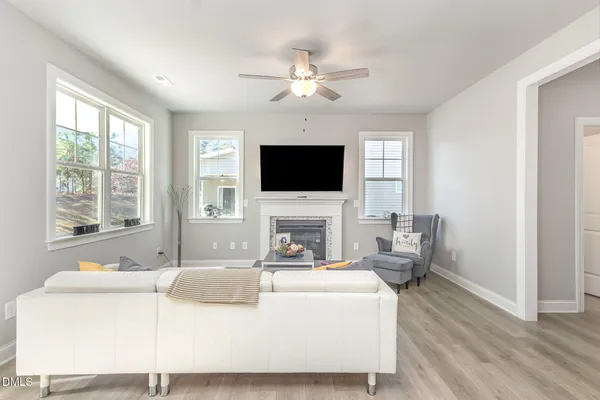 a living room with furniture a fireplace and a flat screen tv