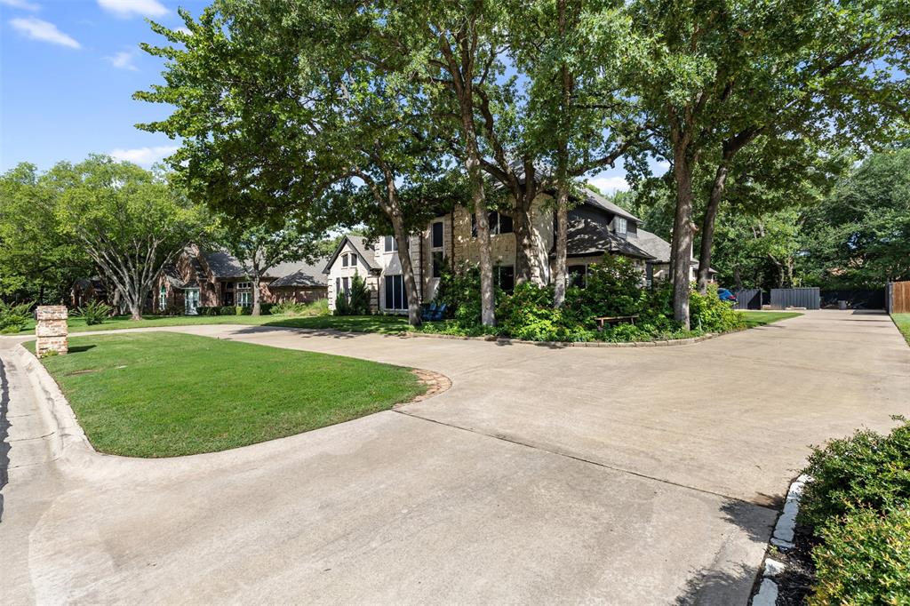 609 Seville Road Denton, TX 76205 - Photo 12 of 40 View of home with circular drive, plus long driveway leads to 2 car garage. Lush landscaping.