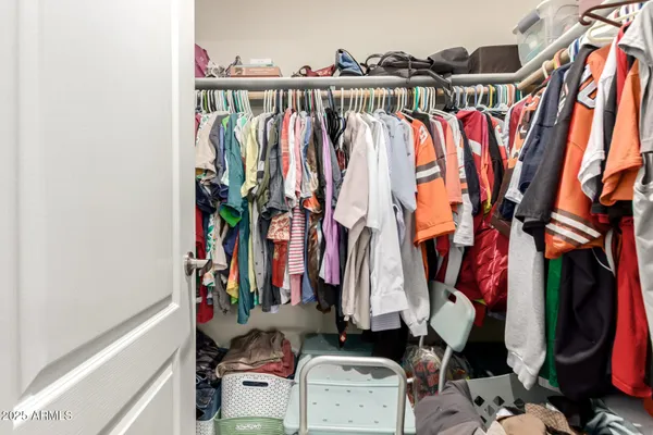a view of walk in closet with clothes and shoes