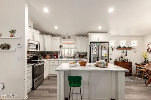 a kitchen with sink a stove and chairs