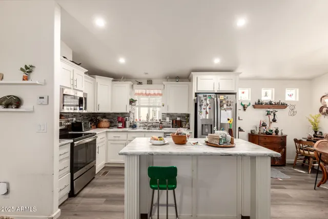 a kitchen with sink a stove and chairs
