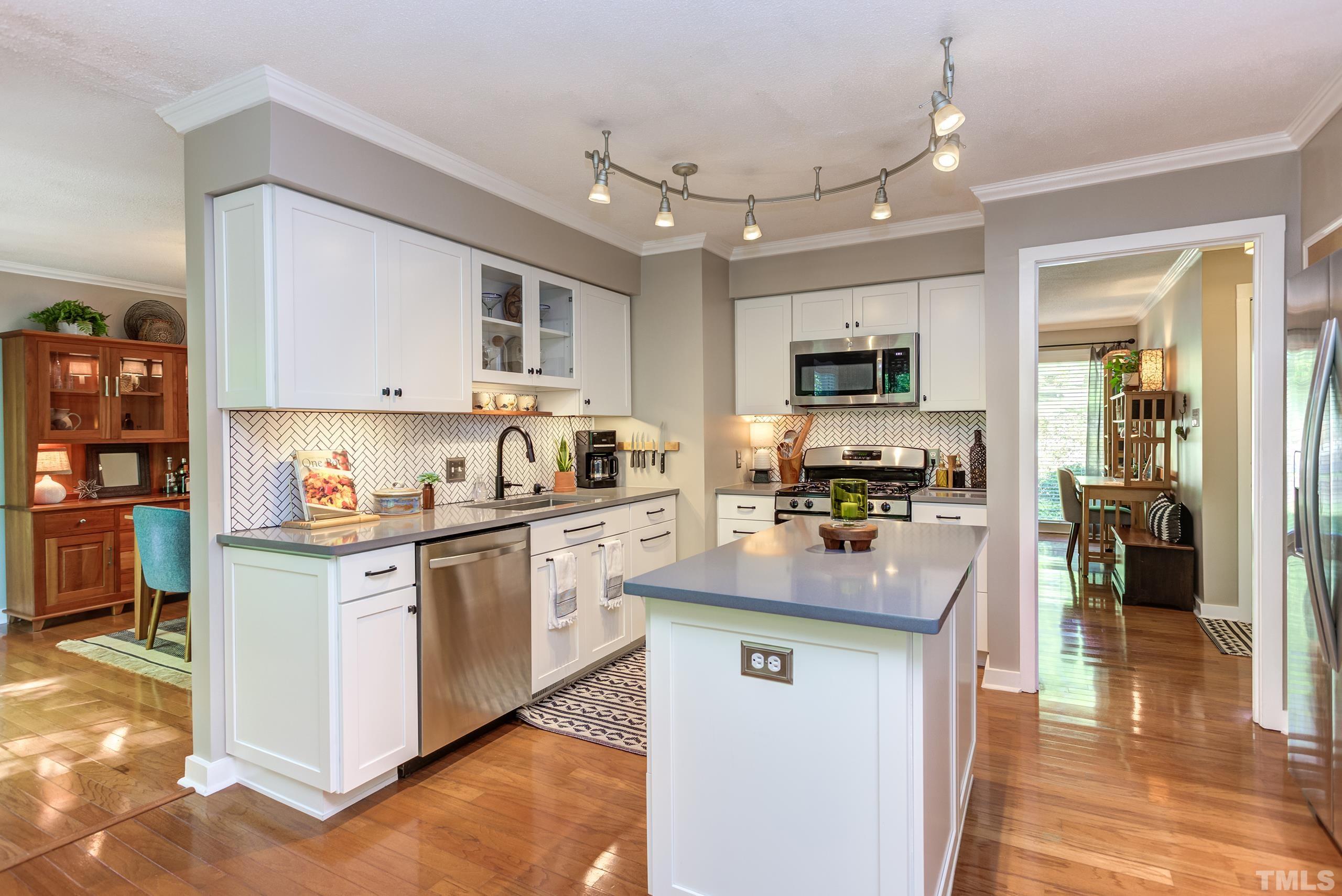 6316 Rushingbrook Drive Raleigh, NC 27612 - Photo 18 of 50 a kitchen with stainless steel appliances granite countertop a stove top oven a sink a counter top space and cabinets