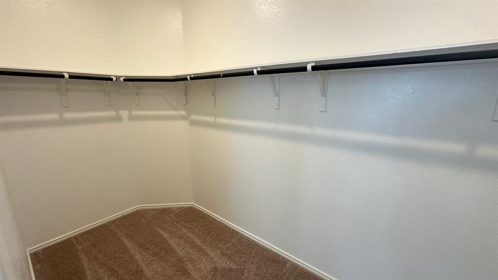192 Rodney Boat Road Kyle, TX 78640 - Photo 13 of 38 A well-organized closet space with ample hanging rods provides practical storage solutions.