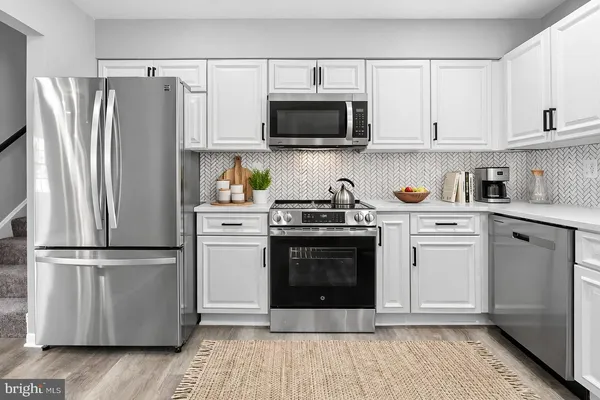 a kitchen with white cabinets and stainless steel appliances