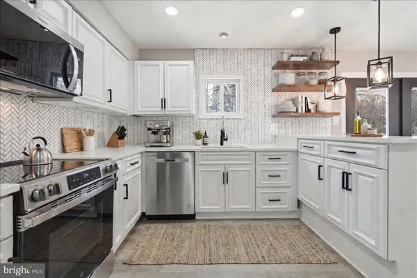 a kitchen with white cabinets and white appliances